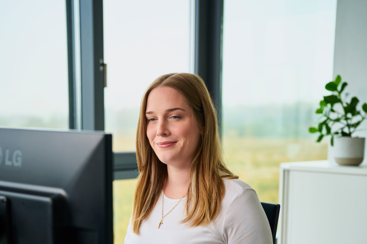 Mitarbeiterin von Fritz schaut lächelnd auf Ihren Bildschirm